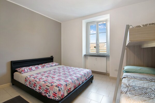A bedroom with a bed, a window, and a bunk bed. - Holiday Apartment "Colico Center" with Lake View and Wi-Fi (Colico)