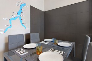 Ein Esstisch gedeckt mit Tellern, Gläsern und Besteck, mit einer Karte an der Wand.