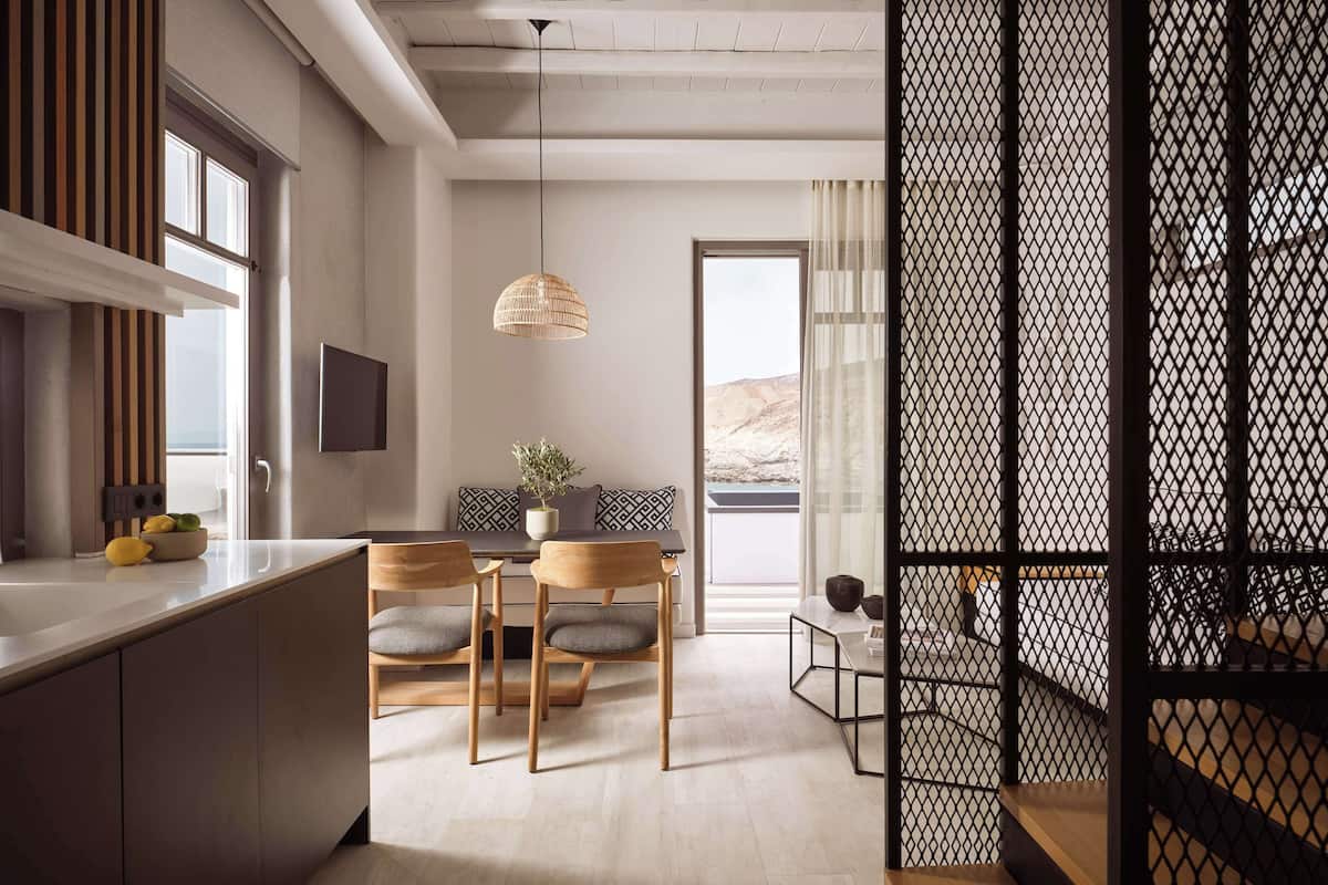 A modern kitchen with a dining area, a large window, and a view of the outdoors.