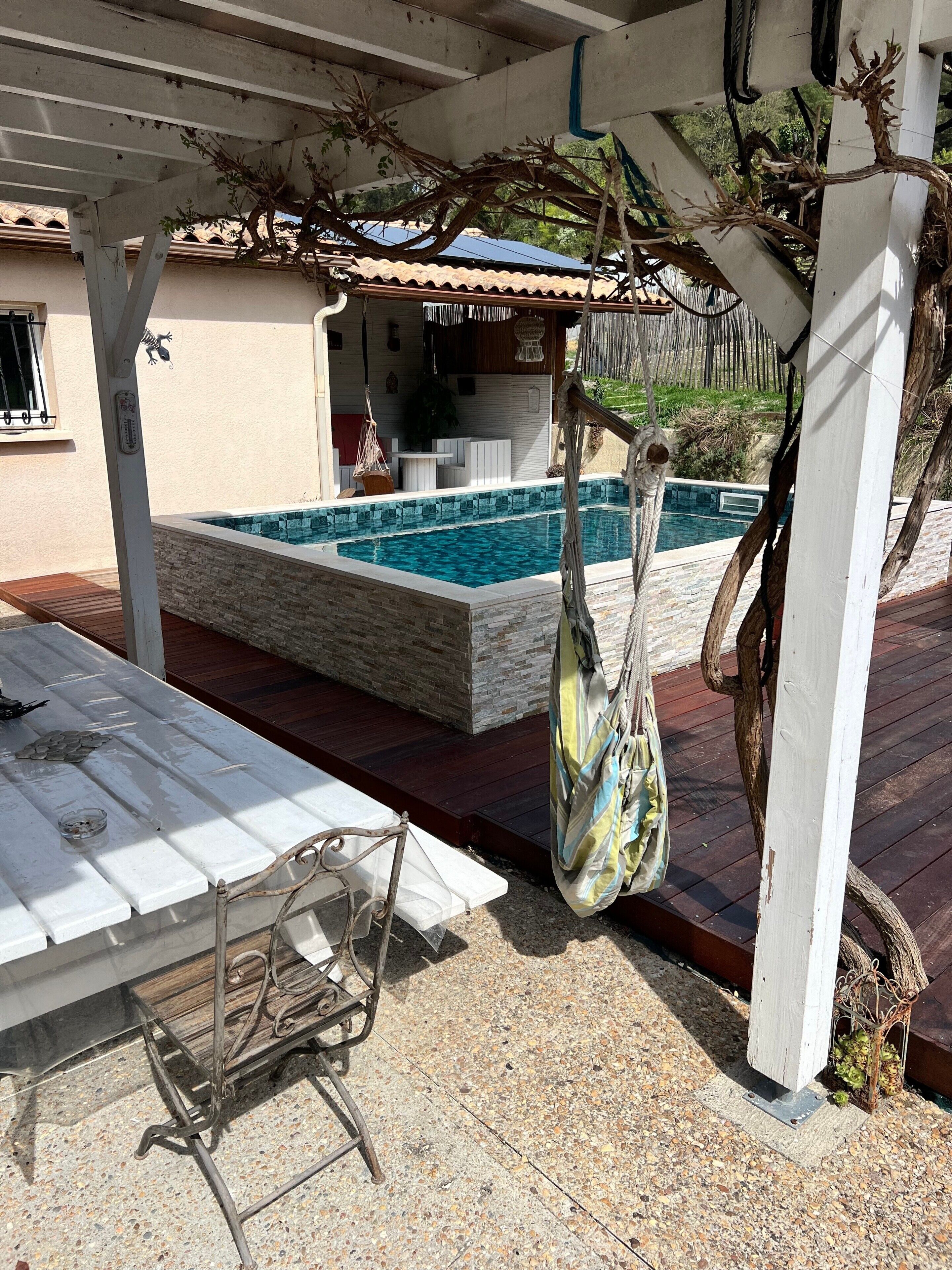 Un espacio al aire libre cubierto con piscina, una bolsa colgante y una mesa con monedas.