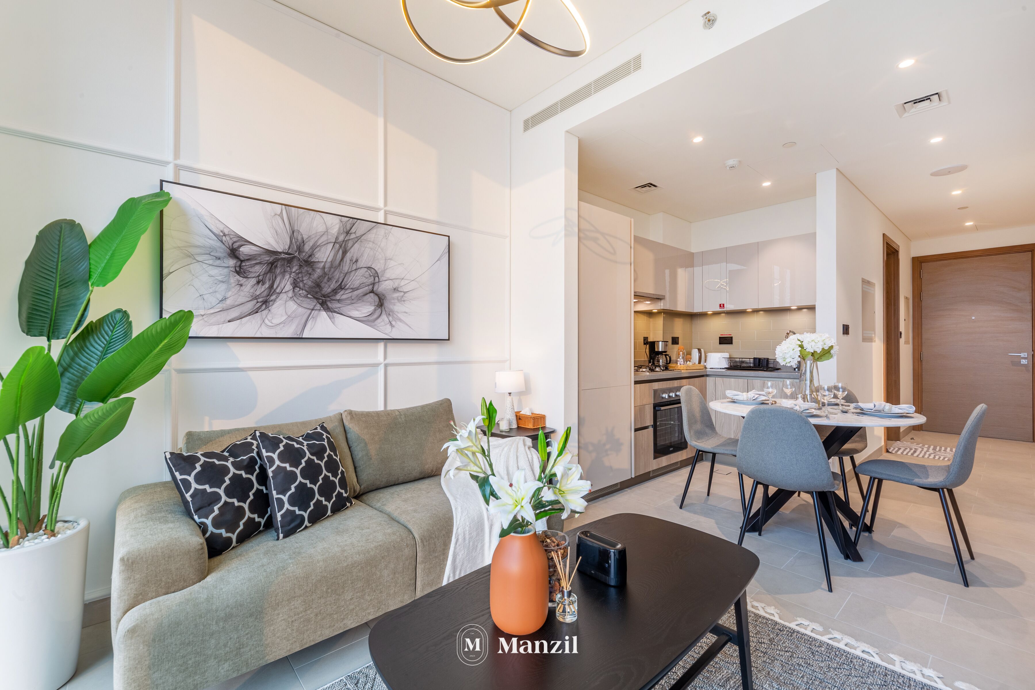A modern living room with a sofa, coffee table, and a dining area with chairs and a table.