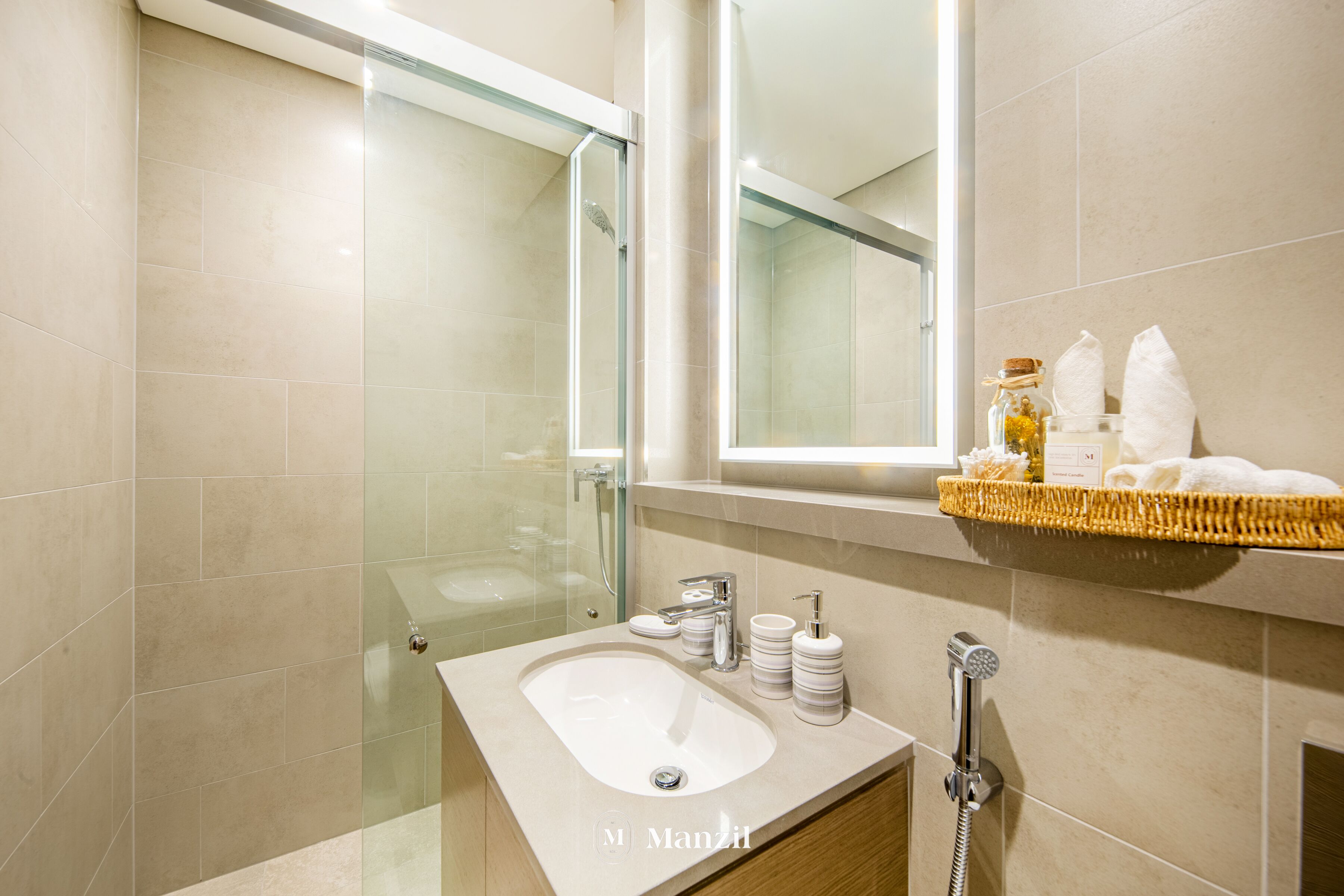 A modern bathroom with a glass shower enclosure, a vanity with a sink, and a shelf with towels and toiletries.