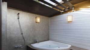 Une salle de bain moderne avec une baignoire sur pieds, une douche et deux appliques murales.