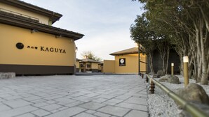 Un chemin pavé mène à un bâtiment sur lequel est apposée une enseigne indiquant « KAGUYA ».