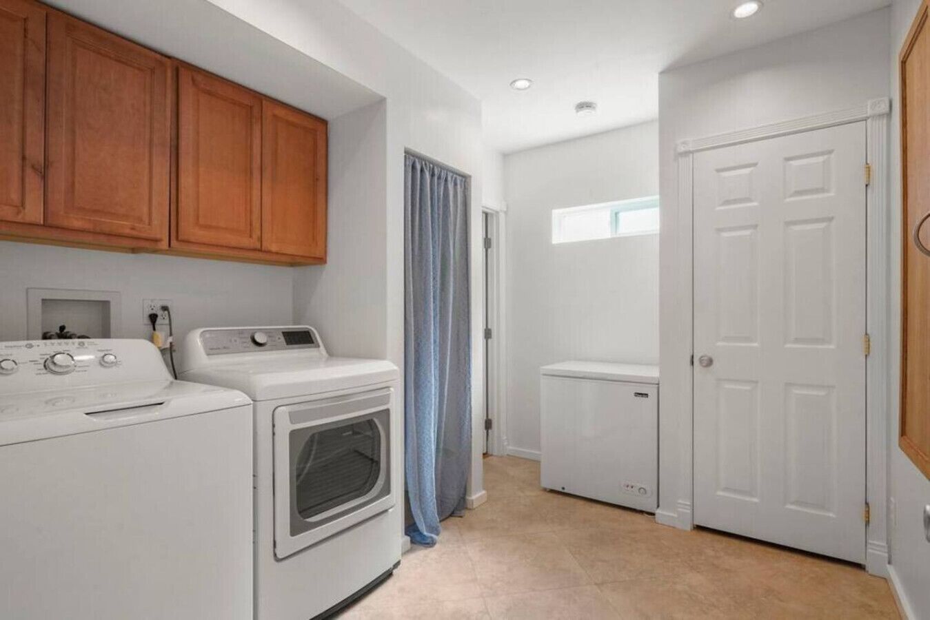 A laundry room with a washer, dryer, and a utility room.