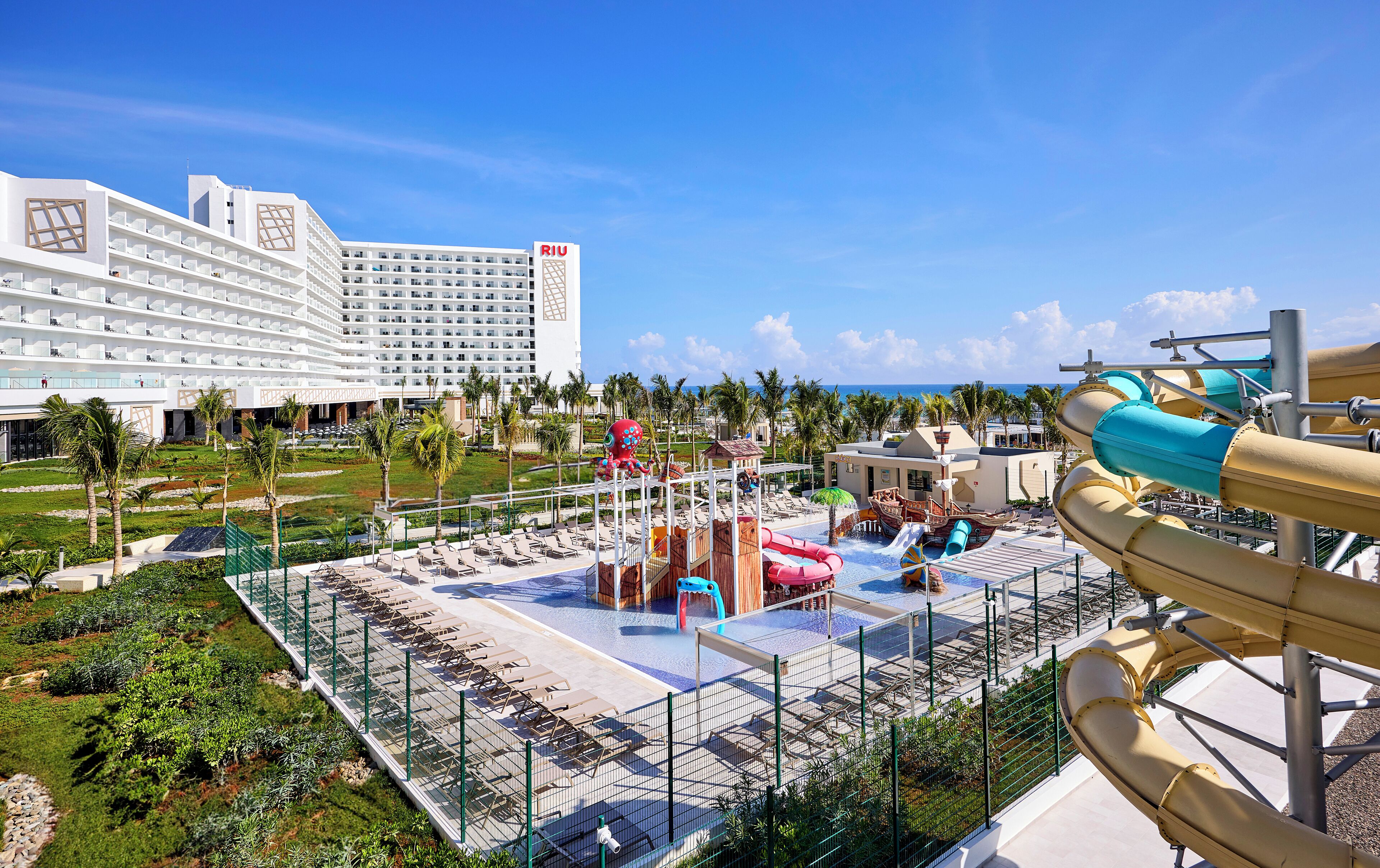 Un resort con parco acquatico, che include scivoli e un fiume lento, e un ampio edificio hotel sullo sfondo.