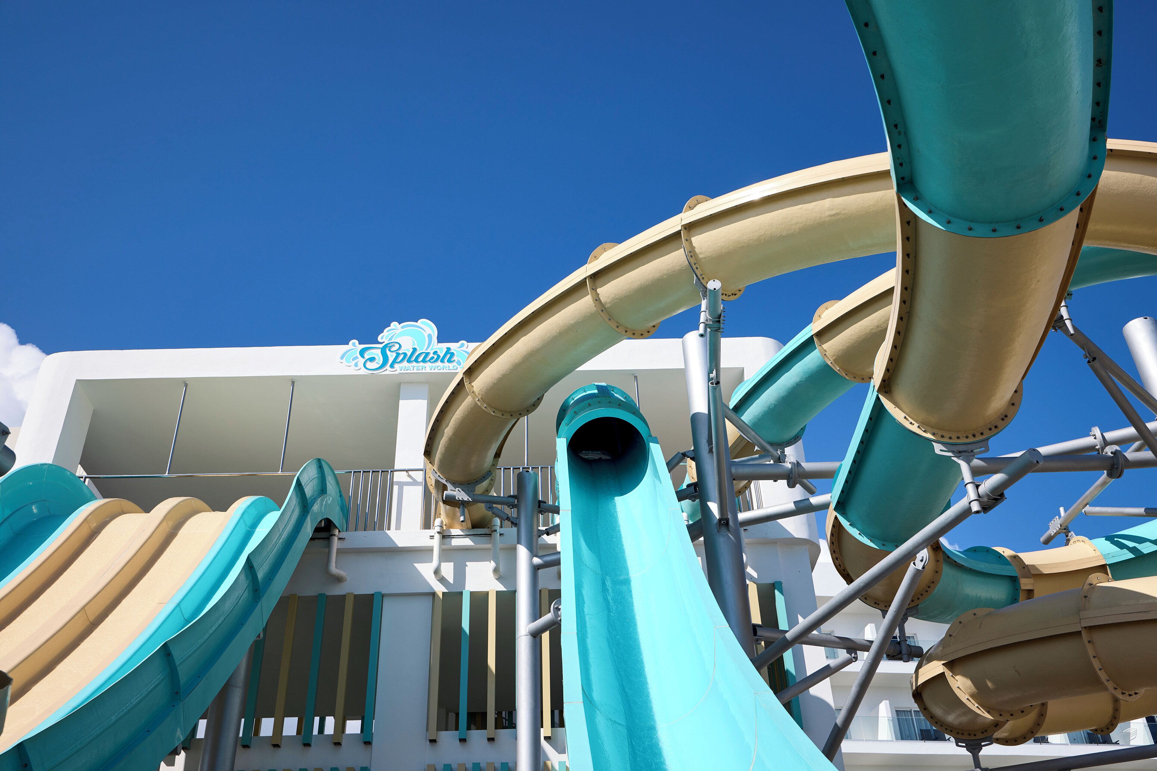 A water park structure with multiple slides and a sign that reads "Splash Water World".
