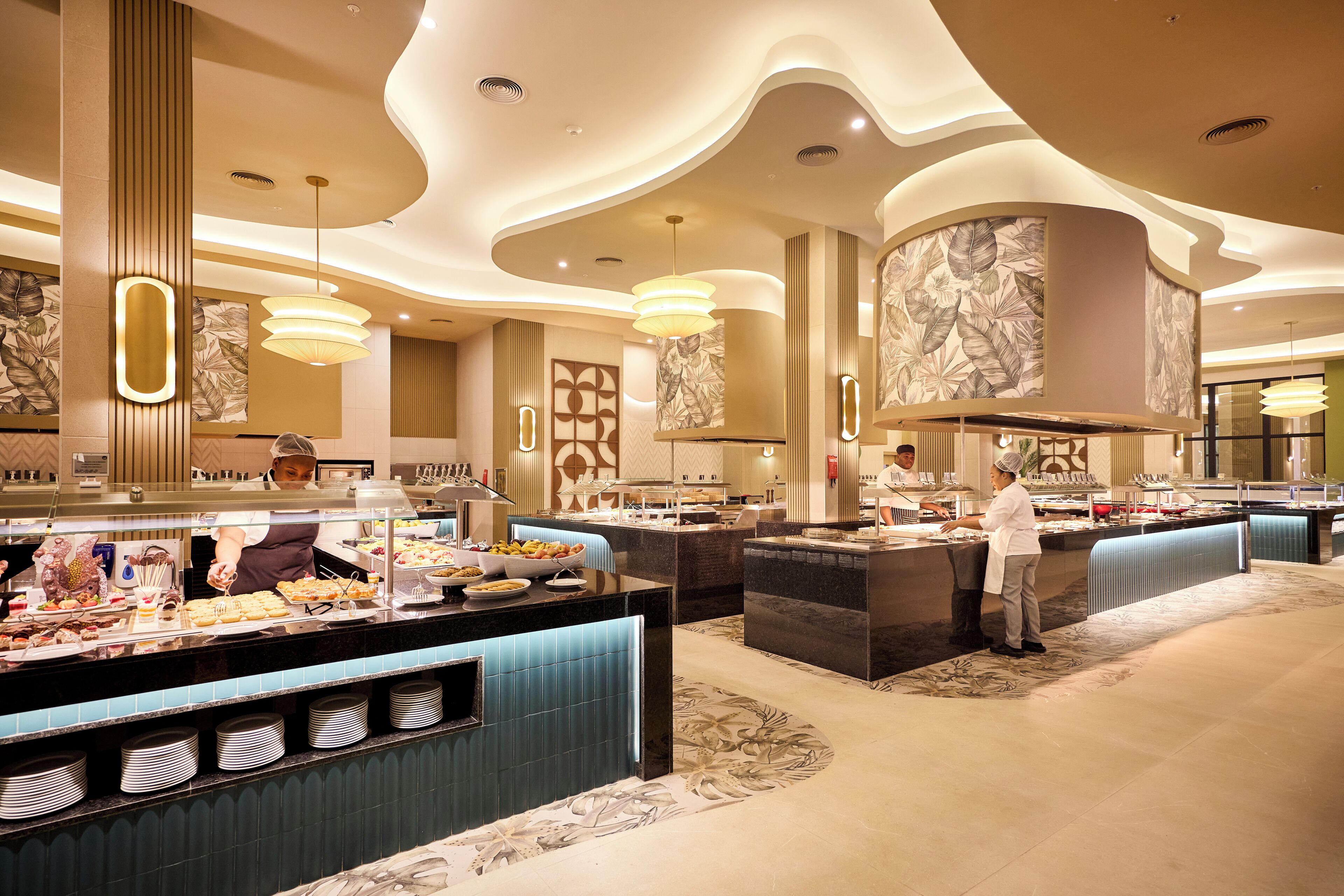 A buffet area with multiple serving stations, a marble-patterned wall, and a modern ceiling design.