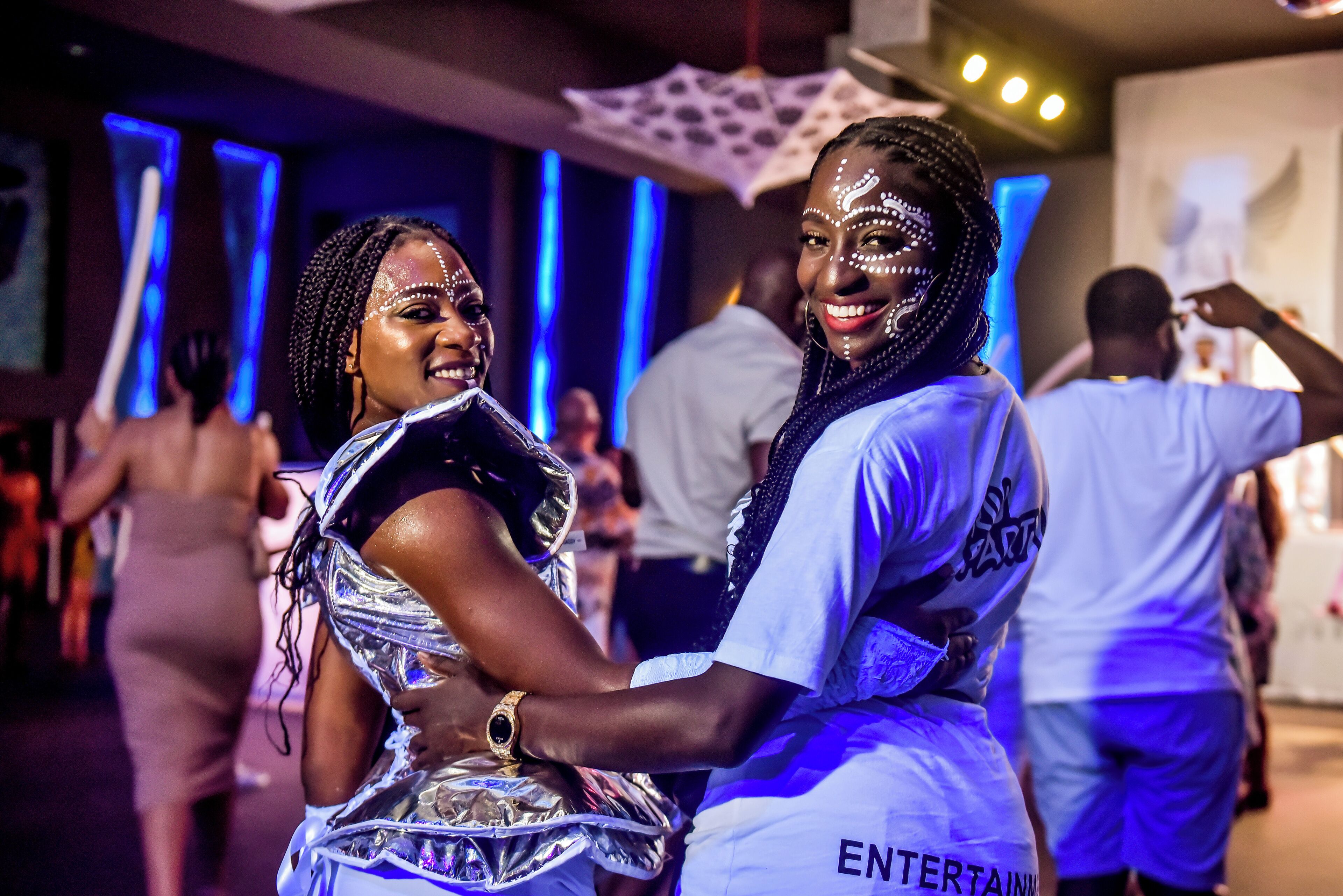 A person in a white shirt with "ENTERTAIN" on the back, holding a trophy.