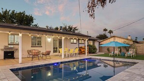A backyard with a swimming pool, outdoor seating, and a barbecue area. - Boho Chic, Mtn Preserve Hike, Pool, & Grille! (phoenix)
