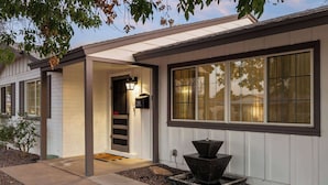 A modern house with a covered entryway, large windows, and a small outdoor water feature. - Boho Chic, Mtn Preserve Hike, Pool, & Grille! (phoenix)