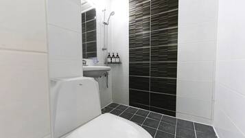 A bathroom with a toilet, sink, and shower.