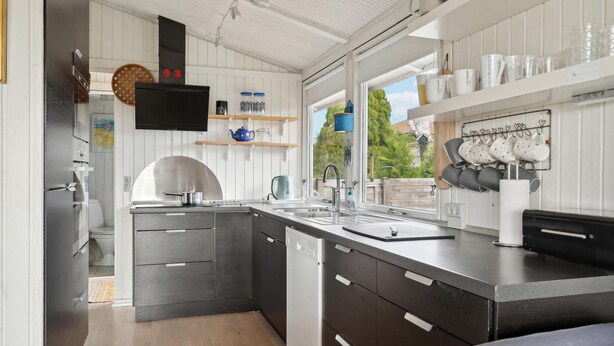 A modern kitchen with a built-in dishwasher, a sink, and a stove. There is a window providing a view of the outdoors. - 3 bedroom gorgeous home in Assens (Assens)