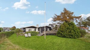A modern house with a large deck, a flagpole, and a well-maintained lawn. - 3 bedroom gorgeous home in Assens (Assens)