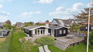 A modern house with a deck, a small garden, and a wooden fence. - 3 bedroom gorgeous home in Assens (Assens)