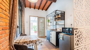 Une cuisine compacte équipée d’un four à micro-ondes, d’un réfrigérateur et d’un évier. Un coin repas avec une table et des chaises est également disponible.