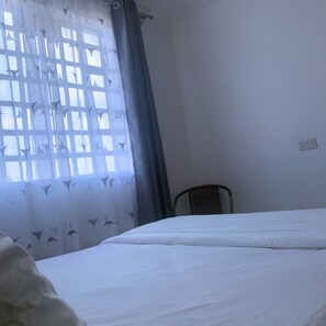 Guests can relax in this simple, functional room featuring a comfortable bed and a window with a view.