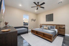 A bedroom with a bed, a sofa, a desk, and a ceiling fan. - Gaming, Pool, Relaxing, and Memories are all made at After Dune Delight! (Hurricane)