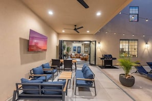 An outdoor patio with seating, a ceiling fan, string lights, and a grill area. - Gaming, Pool, Relaxing, and Memories are all made at After Dune Delight! (Hurricane)