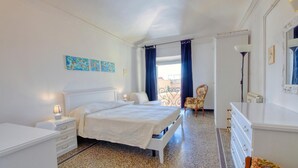Een hotelkamer met een bed, een stoel, een dressoir en een spiegel.