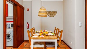 Ein Essbereich mit Holztisch, Stühlen und einer Pendelleuchte.