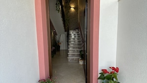 A doorway leading to a staircase with a welcome mat and potted plants. - B&B Le Onde del Mare (San Vito Lo Capo)