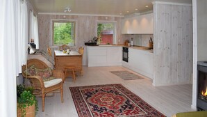 Eine gemütliche Küche mit Essbereich, Holzwänden und einem Kamin.