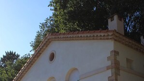 A building with a white facade, stone base, and arched windows.