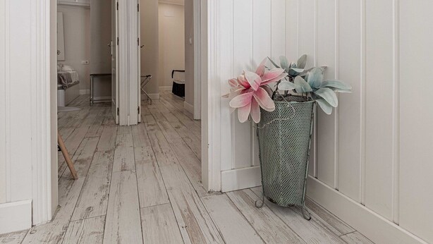 A hallway with white walls and wooden flooring, leading to a room with a bed and a bathroom. - Recaredo, Nº3- Apartment 2 bedrooms 2nd Floor (Sevilla)