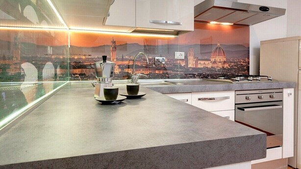 A modern kitchen with a cityscape view, stainless steel appliances, and a sleek countertop. - Apartment in Oltrarno area (Florence)