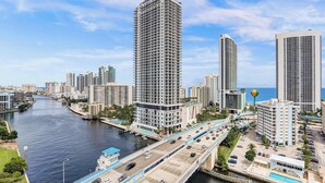 A high-rise hotel with a view of a river and city skyline.