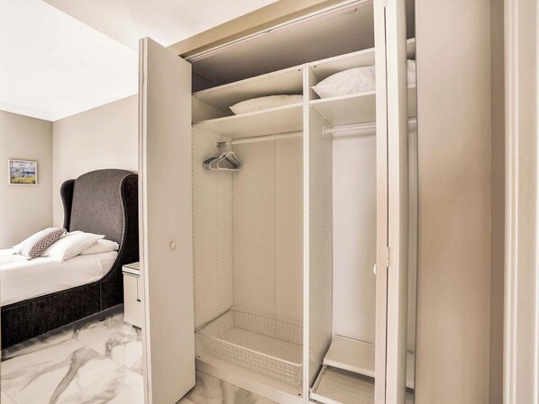 Une chambre à coucher comprenant un lit, une armoire et un dressing.