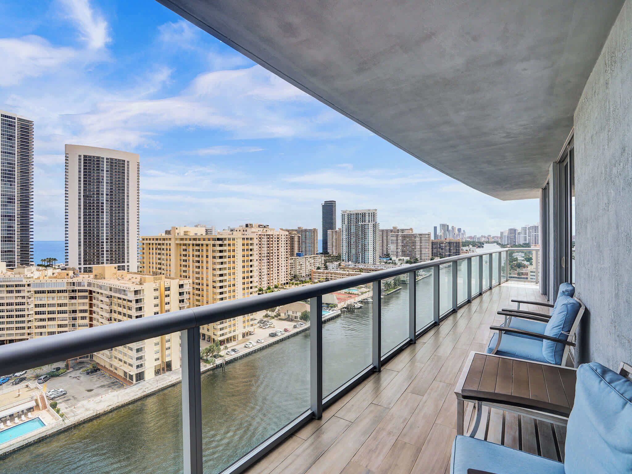A balcony with a view of a cityscape and a river.