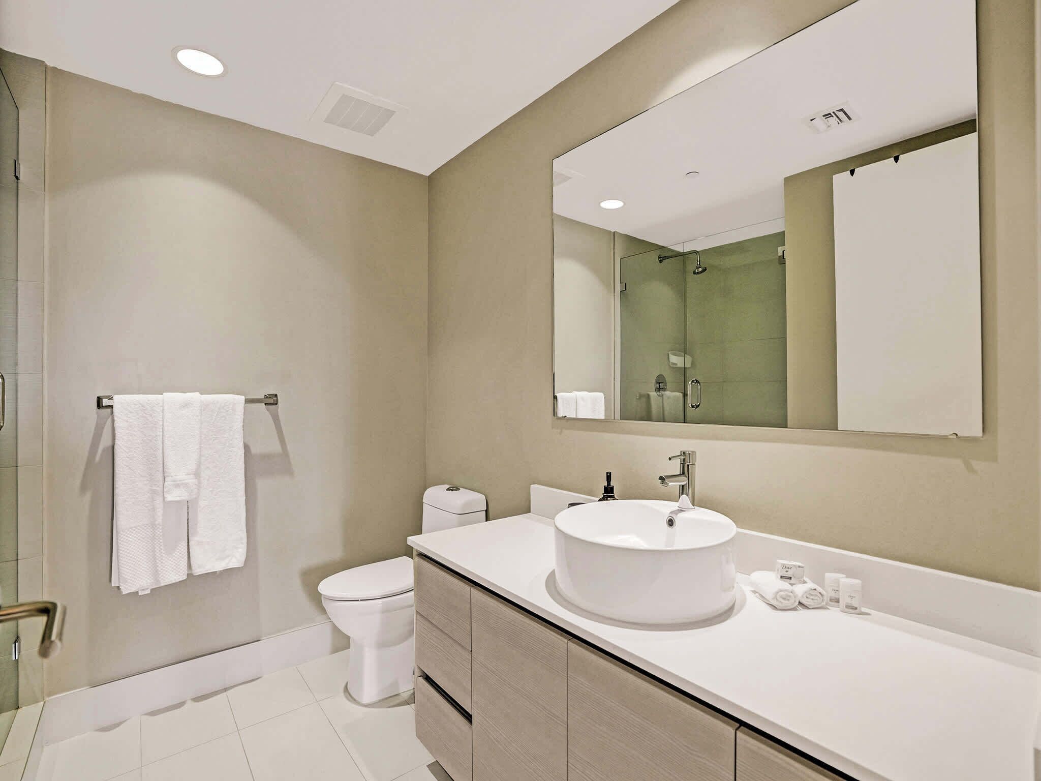 A modern bathroom with a toilet, sink, and shower.