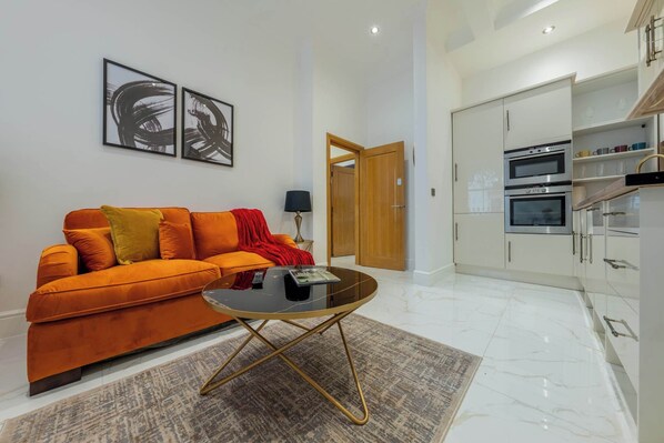 A modern living room with a sofa, coffee table, and artwork on the wall.