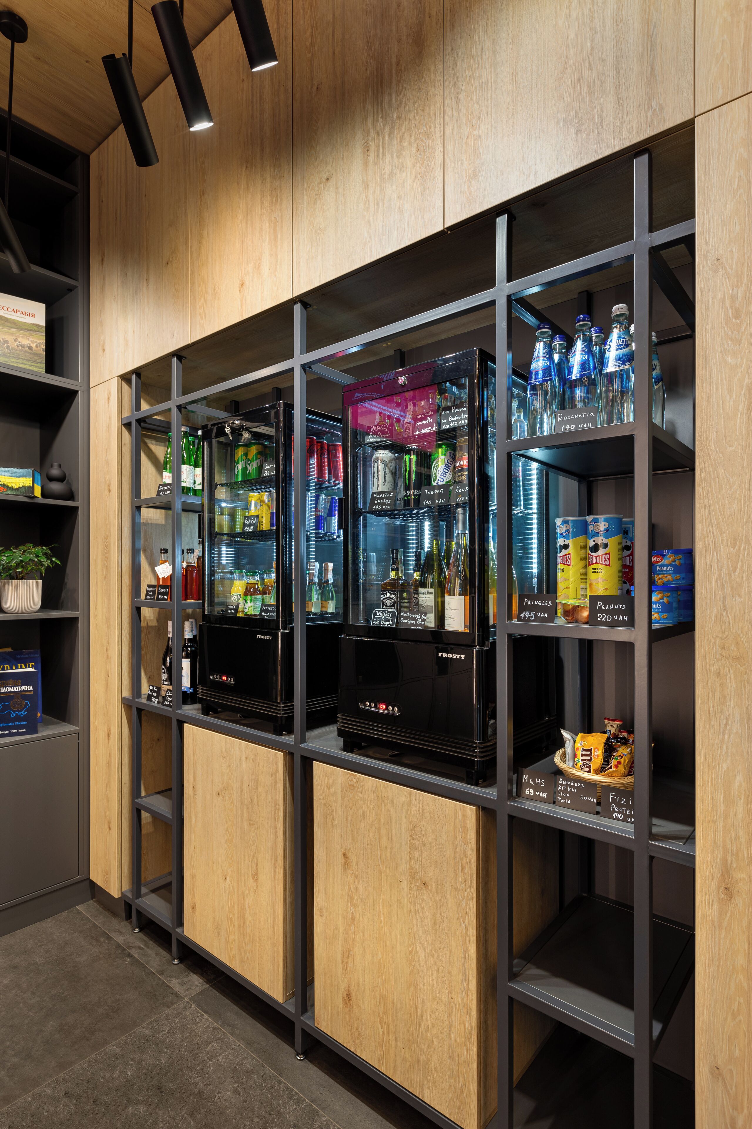 Zona de venta de bebidas con varias neveras llenas de refrescos y aperitivos.