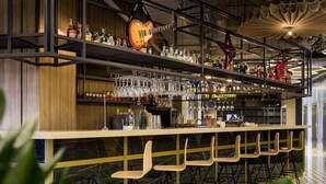 A bar area with multiple shelves of liquor bottles, glasses, and hanging guitars. - Ibis Kyiv Beresteiska (Kyiv)