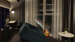 A modern hotel room with a large window, a guitar, a round table, and a chair. - Ibis Kyiv Beresteiska (Kyiv)