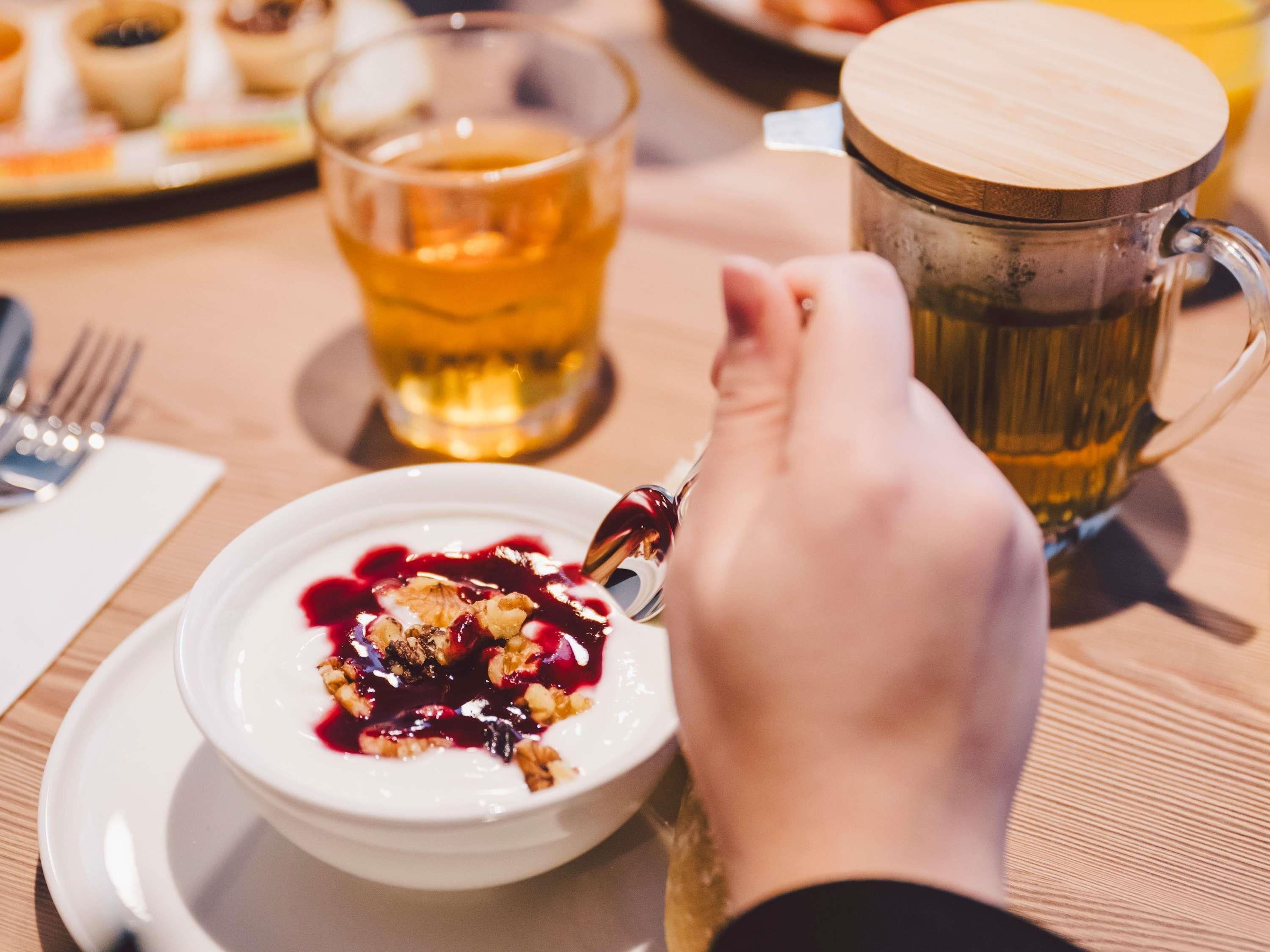 Une table à manger avec une assiette de nourriture, un verre de thé et une tasse.