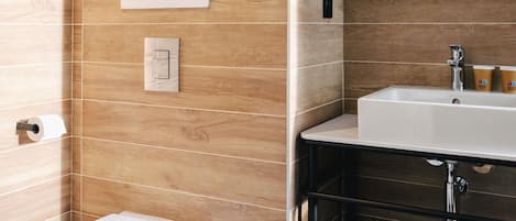 A bathroom with a toilet, sink, and mirror.