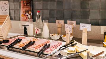 Un buffet proposant une variété de plats, notamment des viandes, des fromages et des produits laitiers, chacun étant accompagné d’une étiquette indiquant son type et son origine.