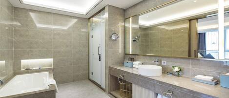 A modern bathroom with a bathtub, a large mirror, and a vanity with a sink.