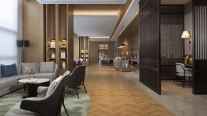 A modern hotel lobby with a spacious layout, a sofa, chairs, a coffee table, and a dining area. - Novotel Yancheng Exhibition Center (Yancheng)