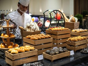 A bakery display with various baked goods in wooden crates. - Pullman Quanzhou Shuitou (Quanzhou)