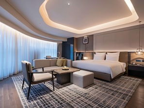 A modern hotel room with a large bed, a sofa, a small table, and a desk. - Pullman Quanzhou Shuitou (Quanzhou)
