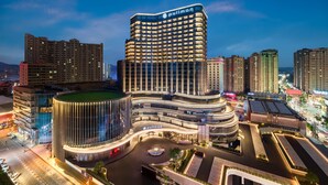 A modern hotel with a curved facade, multiple floors, and a prominent "Pullman" sign. - Pullman Quanzhou Shuitou (Quanzhou)