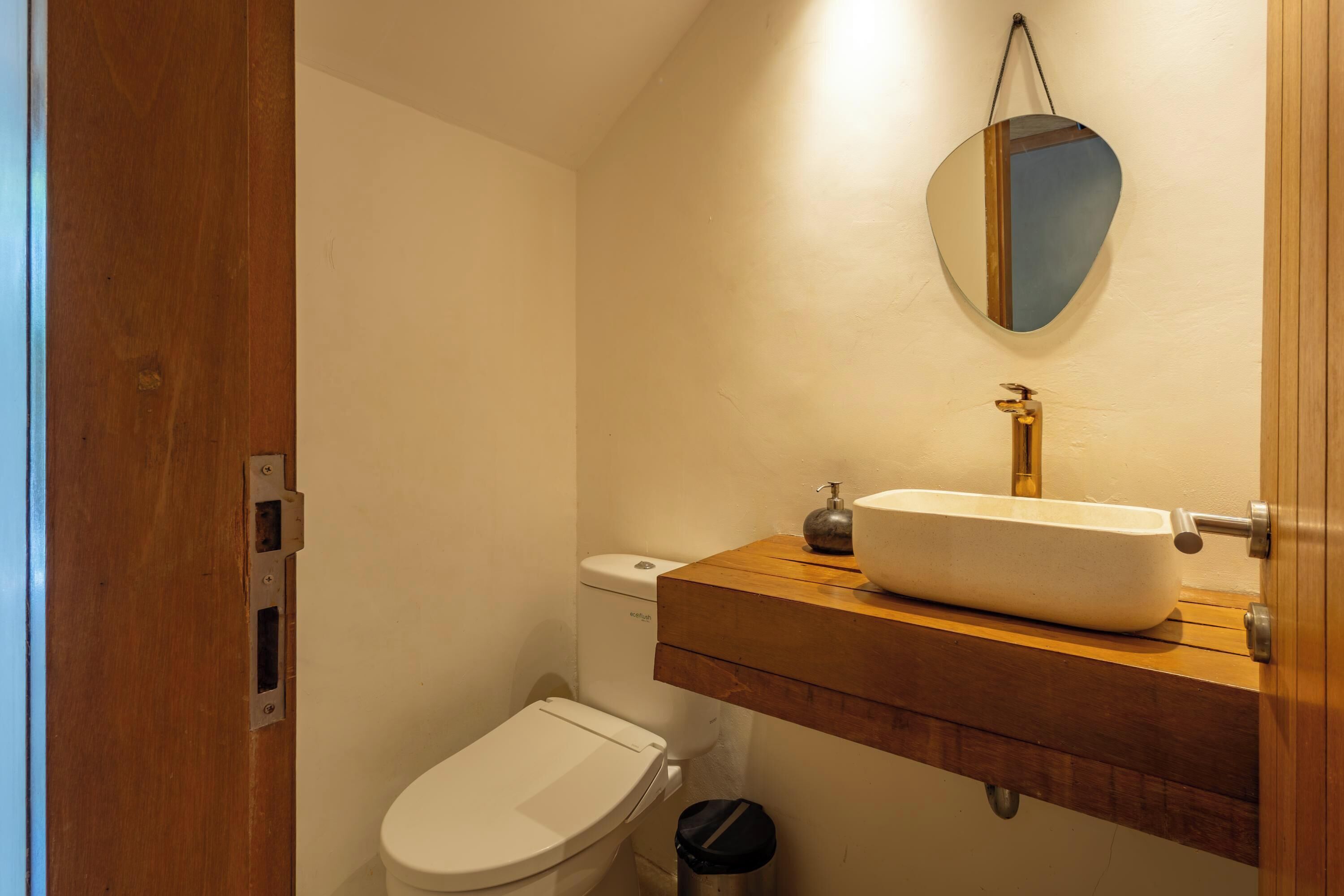 Une salle de bain avec des toilettes, un lavabo et un miroir.