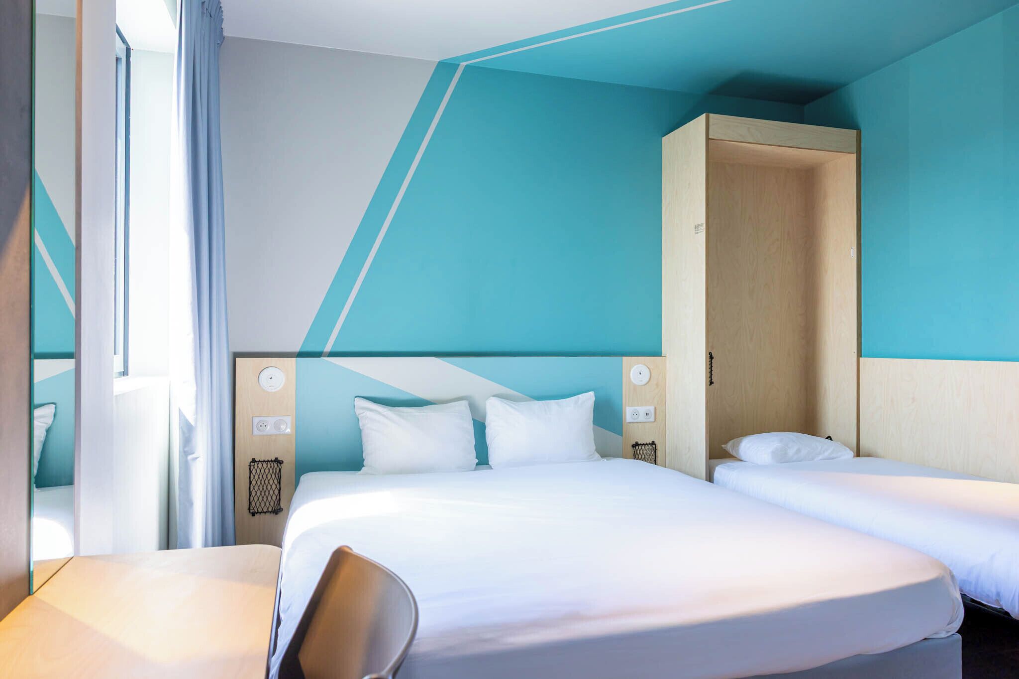 Una habitación de hotel con cama, escritorio y armario.