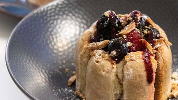 A dessert with berries and nuts on a plate.