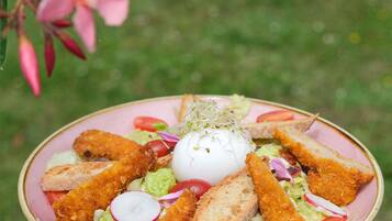 Une assiette composée de poulet pané, d’un œuf poché et d’une salade.